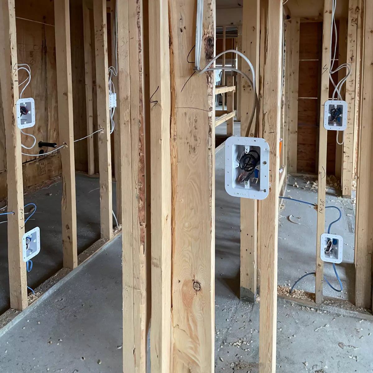 Wooden framing of a room with CONCEAL electrical boxes installed and wiring roughed in
