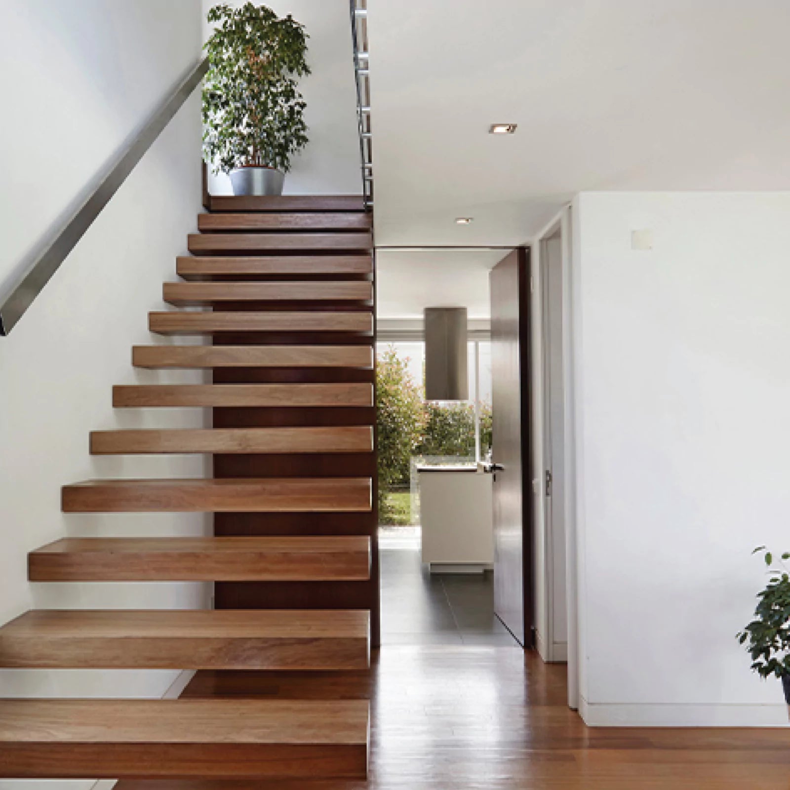 Modern wooden staircase in a home interior with a view of the living area
