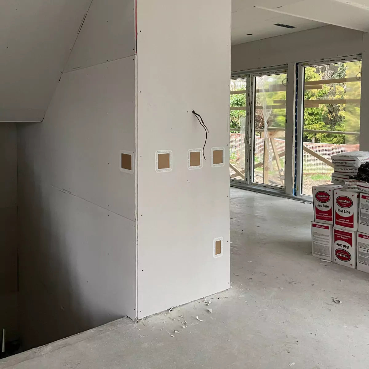 Unfinshed room with drywall sheets hung and CONCEAL mud rings installed, ready for drywall mudding