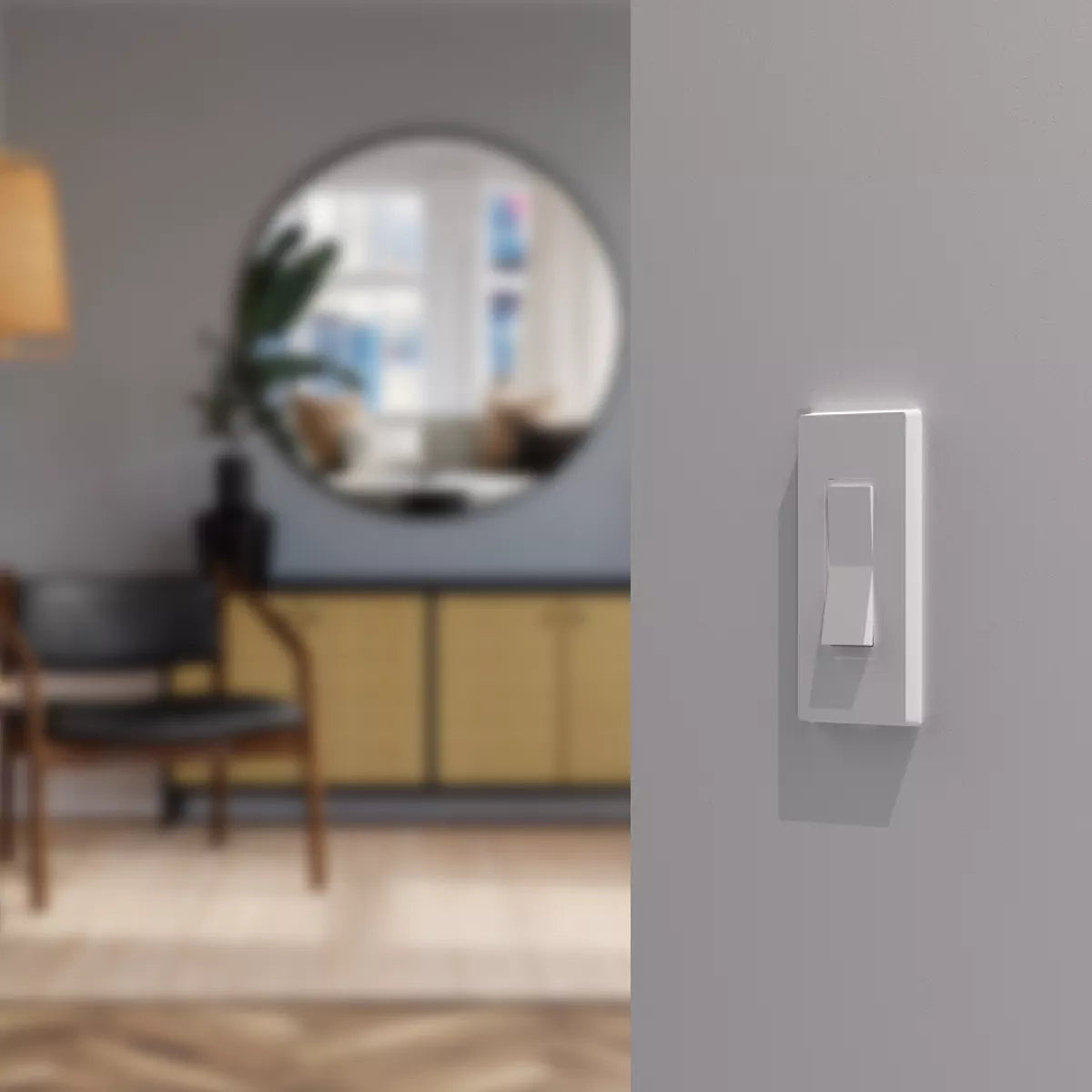 Modern light switch panel on a gray wall with a blurred living room background
