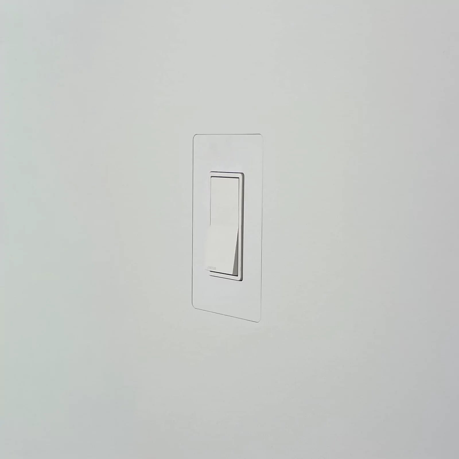 CONCEAL flush-mounted Decora light switch on a white wall with a seamless wall plate for a modern minimalist design.
